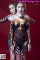 Two women with body paint posing for a picture.