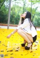 A woman sitting on a yellow floor in a park.