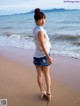 A woman standing on a beach next to the ocean.