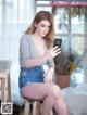 A woman sitting on a stool looking at her phone.